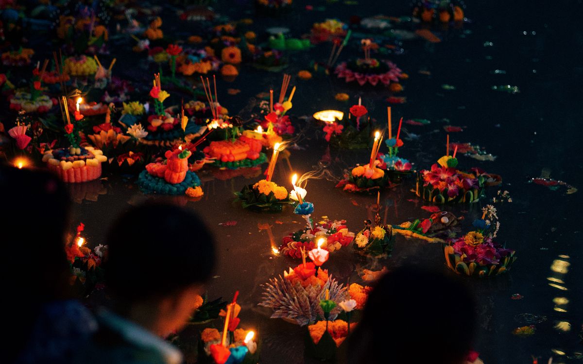 People releasing candlelit krathongs during Loy Krathong in Thailand
