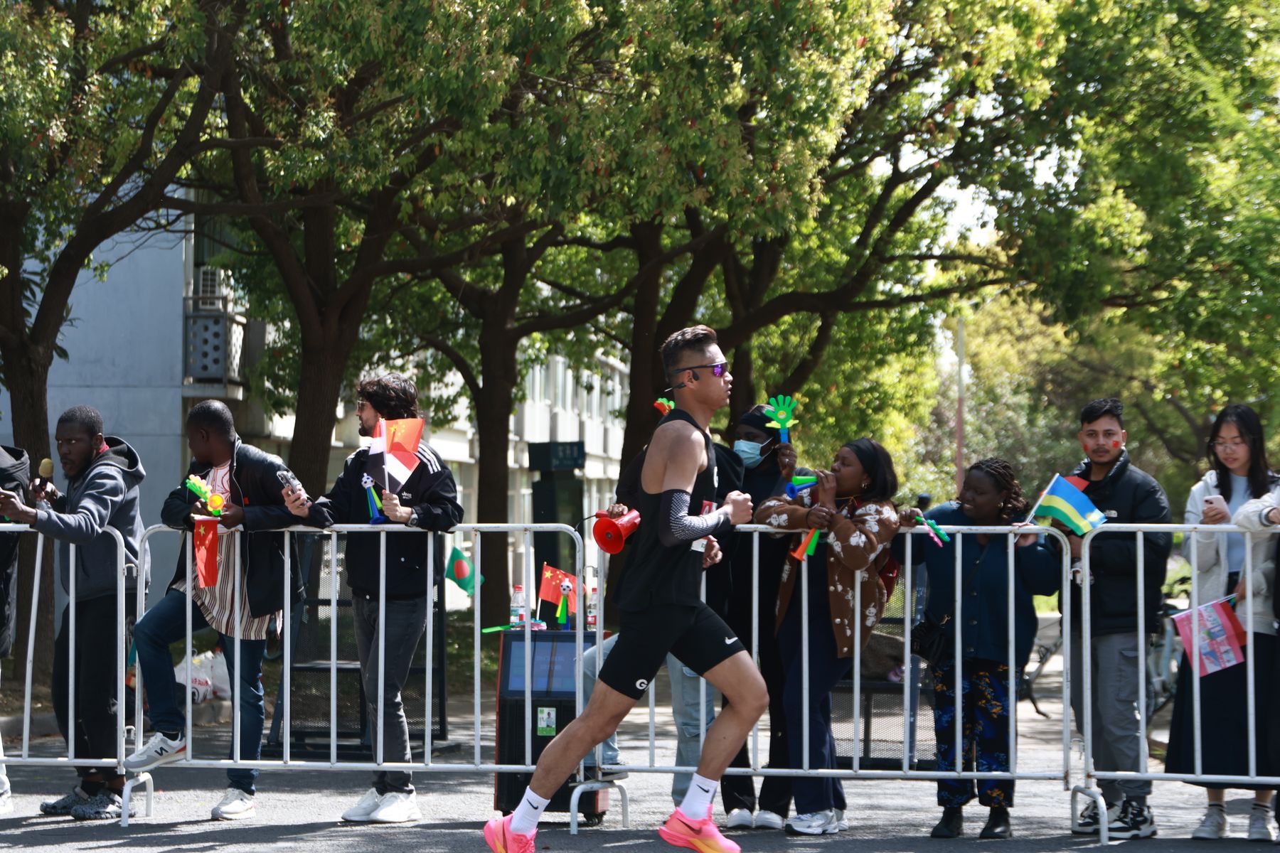 Runner passing an enthusiastic crowd during an outdoor road race