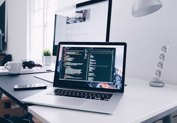 A laptop, notebook and coffee on a remote work desk