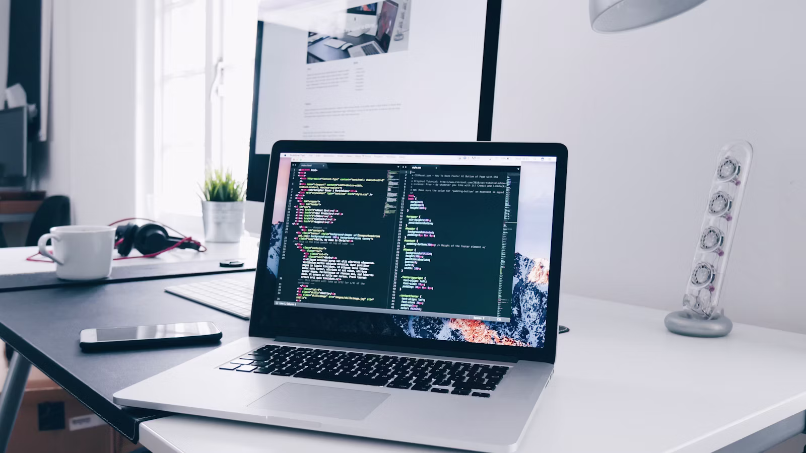 A laptop, notebook and coffee on a remote work desk
