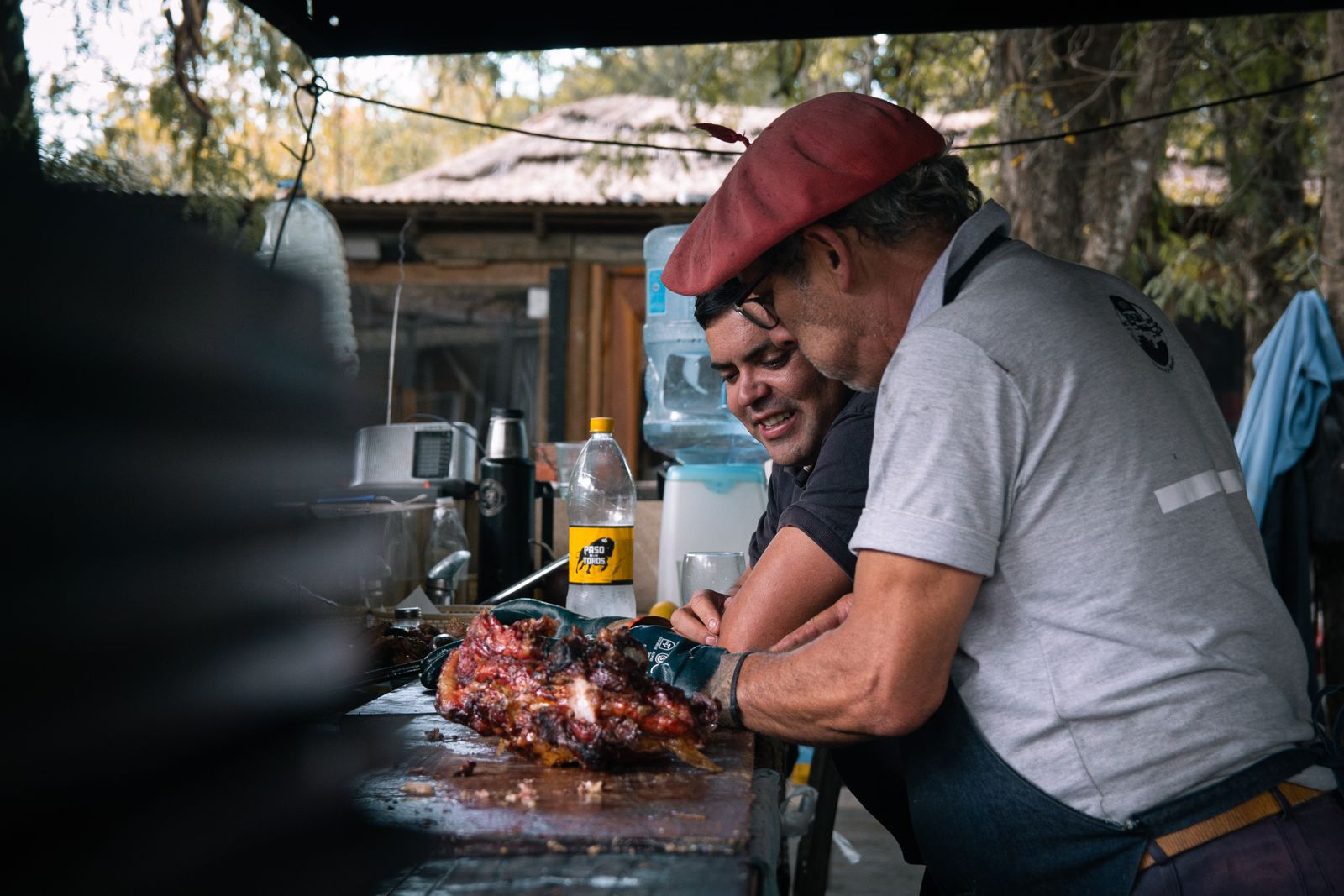 Two chefs preparing food together at an outdoor festival stall