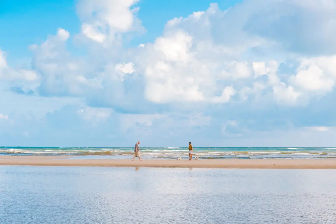 Two people walking along a quiet Phuket beach