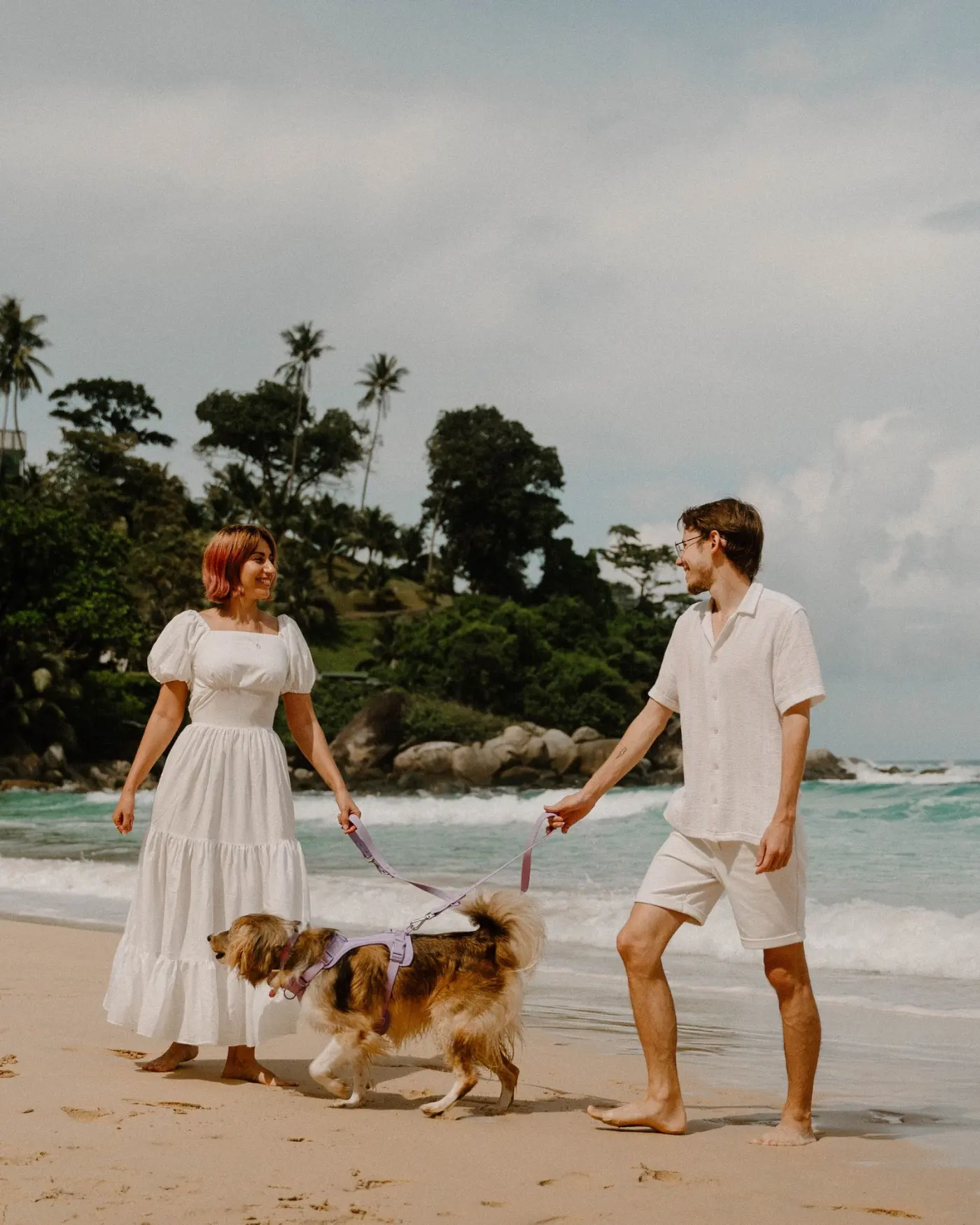 A couple walking their dog on a Phuket beach